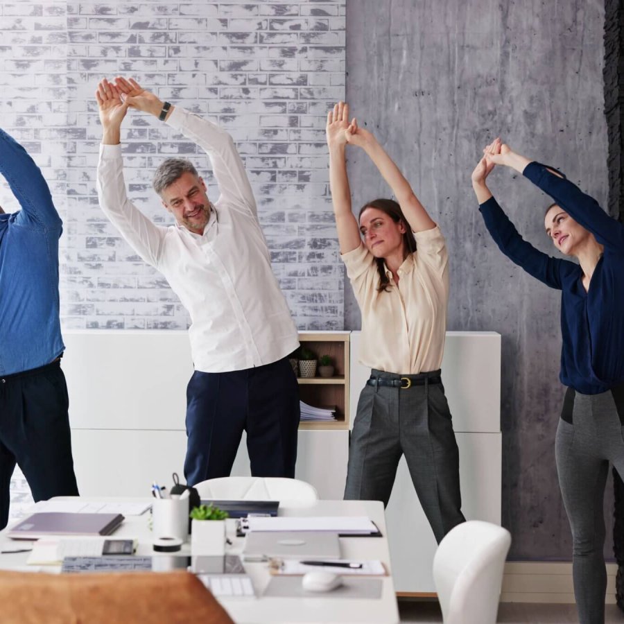 groupe de personne s'étirant dans un bureau, un lieu de travail. sport en entreprise, sport-santé au travail, QVCT, activité physique entreprise